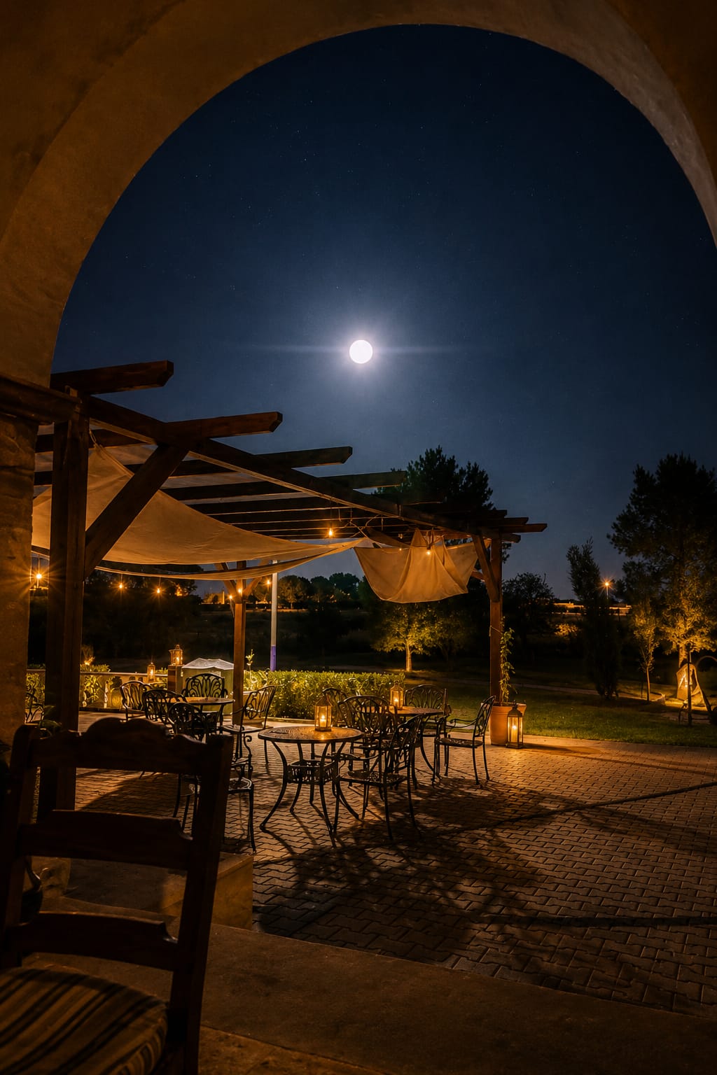 A night view of the Solar de Alcains patio with a full moon and pergola